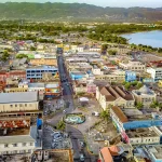 Panoramic view of Montego Bay featuring beaches, palm trees, and tropical landscapes, with tourists exploring the city on a guided tour